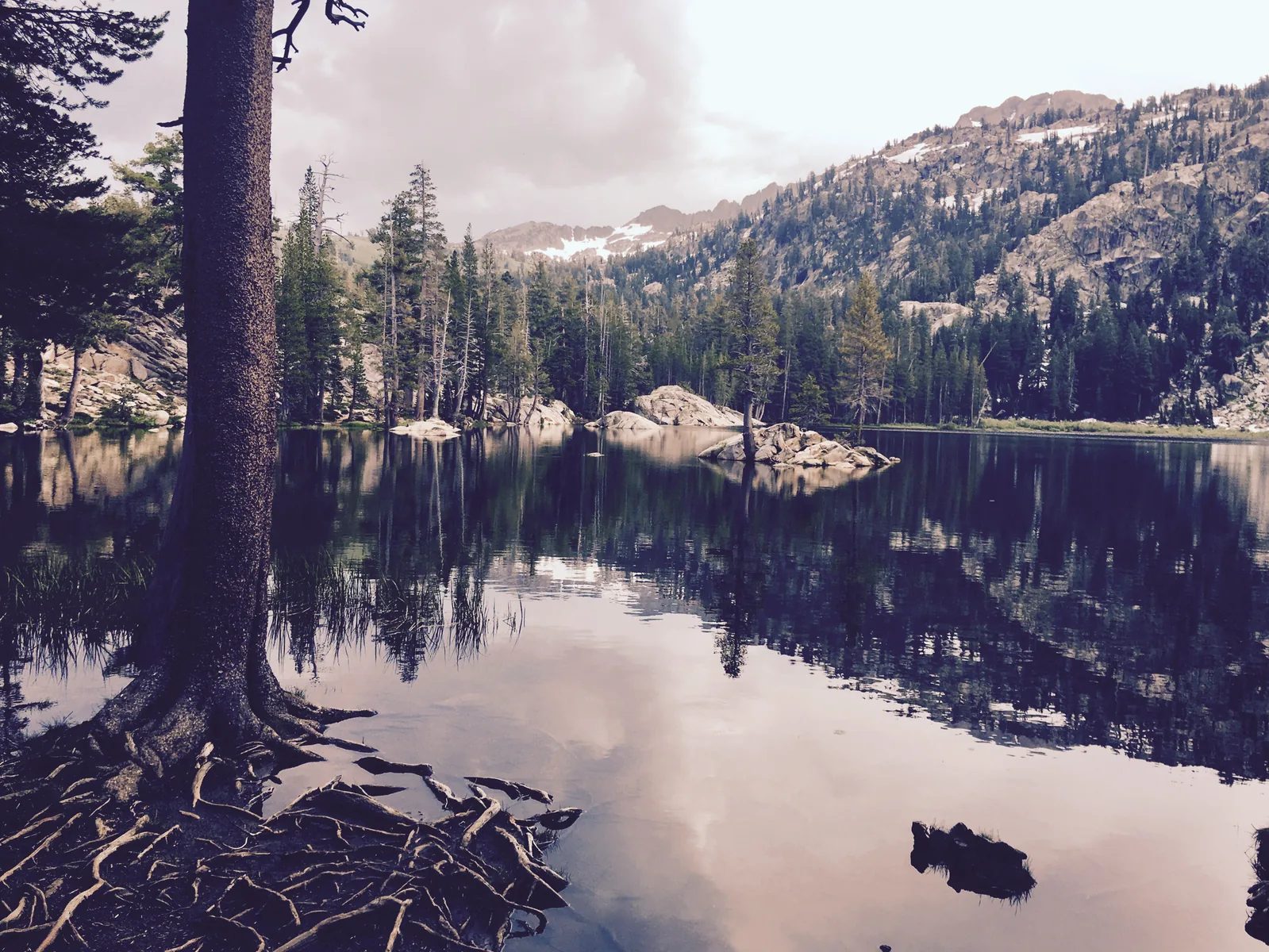 Blue mountain lake bordered by forest and stone